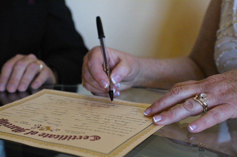 Couple signing their marriage certificate 
